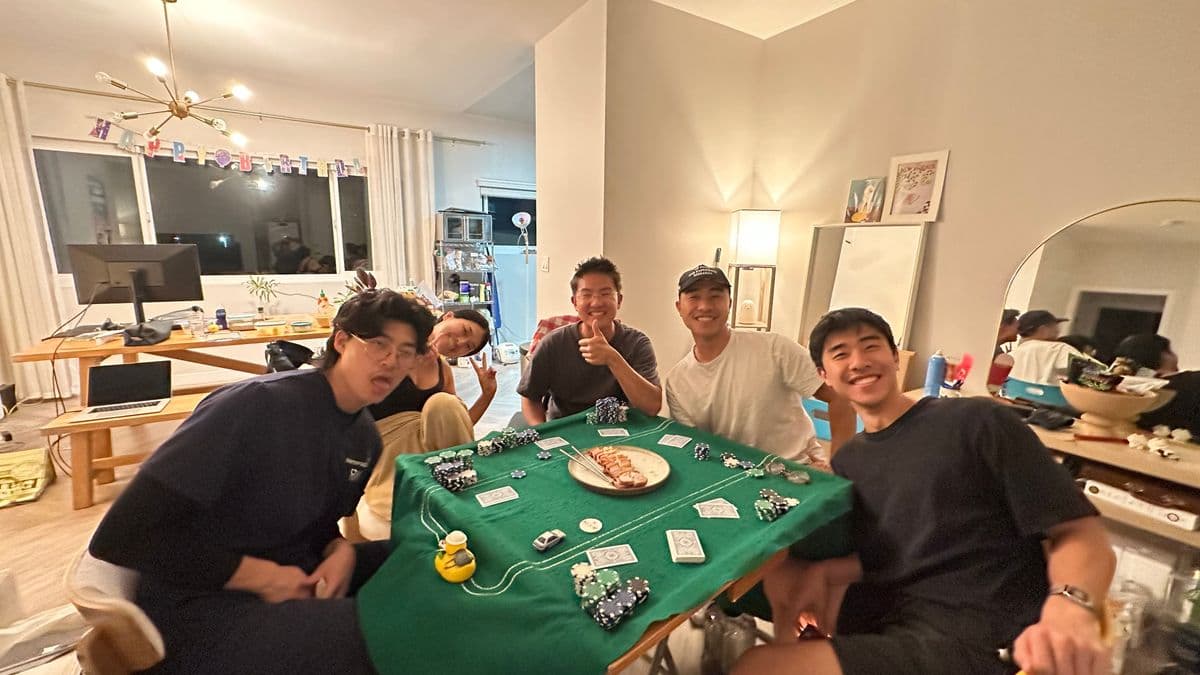 Friends gathered around a poker table during a home game night